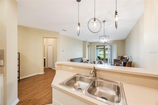 kitchen featuring sink, pendant lighting, and wood-type flooring