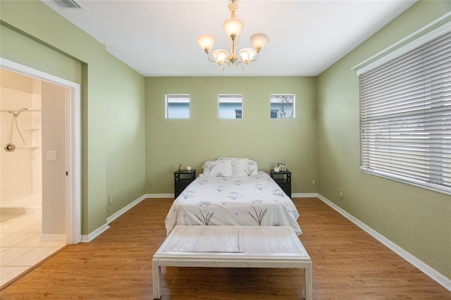 bedroom featuring light hardwood / wood-style flooring and a chandelier