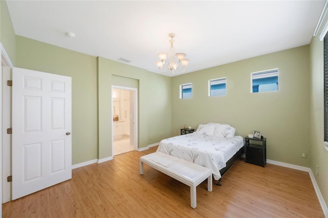 bedroom featuring an inviting chandelier, connected bathroom, and light wood-type flooring