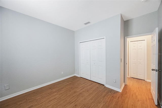 unfurnished bedroom with a closet and light hardwood / wood-style flooring