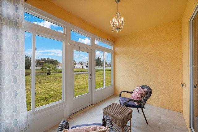 sunroom / solarium featuring a notable chandelier