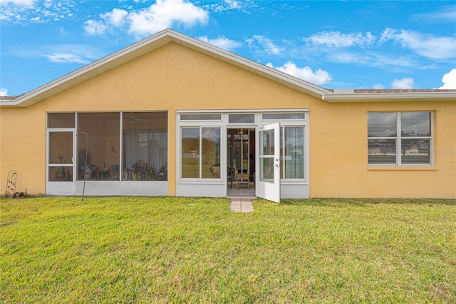 back of property featuring a sunroom and a yard