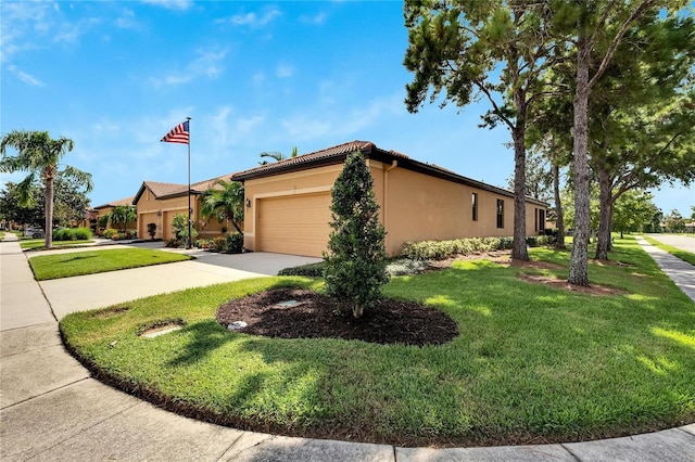 view of front facade with stucco siding, an attached garage, concrete driveway, and a front yard