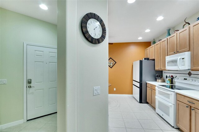 kitchen featuring light countertops, white appliances, light tile patterned floors, decorative backsplash, and light brown cabinets