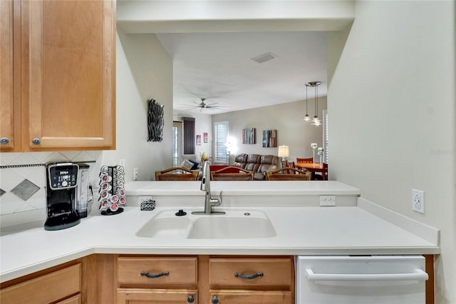 kitchen featuring light countertops, backsplash, a sink, dishwashing machine, and ceiling fan