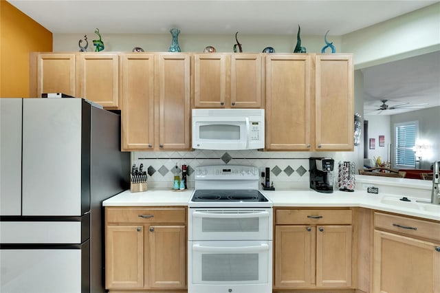 kitchen with a sink, tasteful backsplash, light brown cabinets, white appliances, and ceiling fan