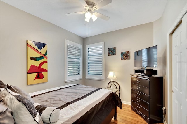 bedroom featuring a closet, ceiling fan, baseboards, and light wood-style floors