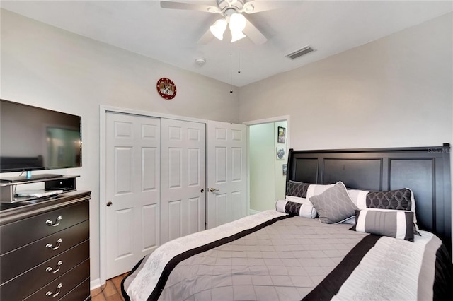bedroom with a closet, ceiling fan, visible vents, and wood finished floors