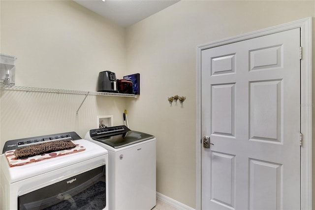 washroom featuring washer and clothes dryer, laundry area, and baseboards