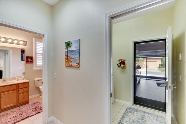 doorway with light tile patterned flooring and sink