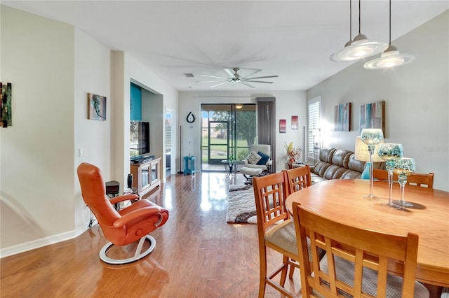 dining area featuring a ceiling fan, baseboards, and wood finished floors