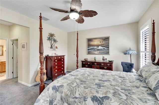 carpeted bedroom featuring baseboards, ensuite bath, visible vents, and a ceiling fan