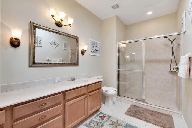 bathroom featuring tile patterned floors, vanity, toilet, and an enclosed shower