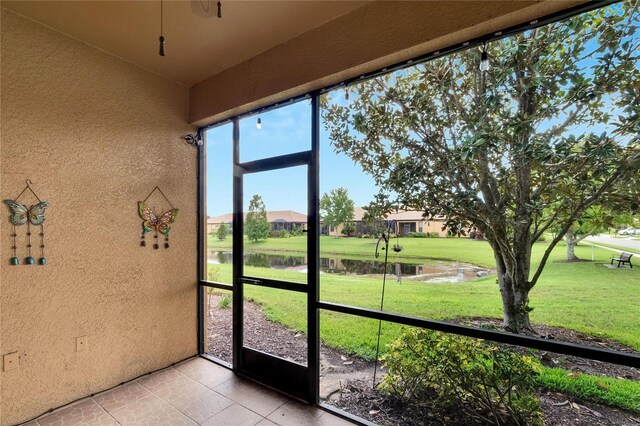 unfurnished sunroom featuring a water view