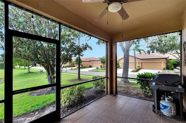 unfurnished sunroom with a residential view and ceiling fan