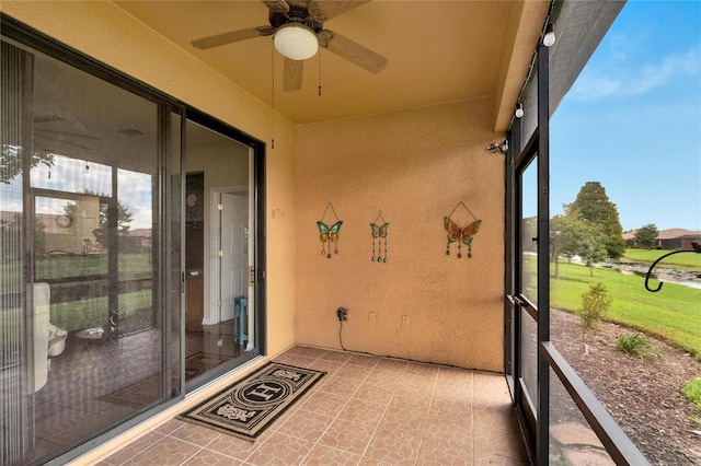 unfurnished sunroom featuring a ceiling fan
