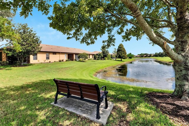 surrounding community featuring a lawn and a water view