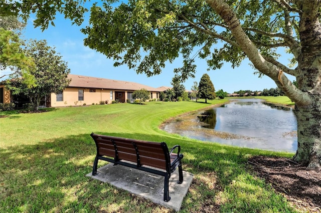 view of property's community featuring a lawn and a water view