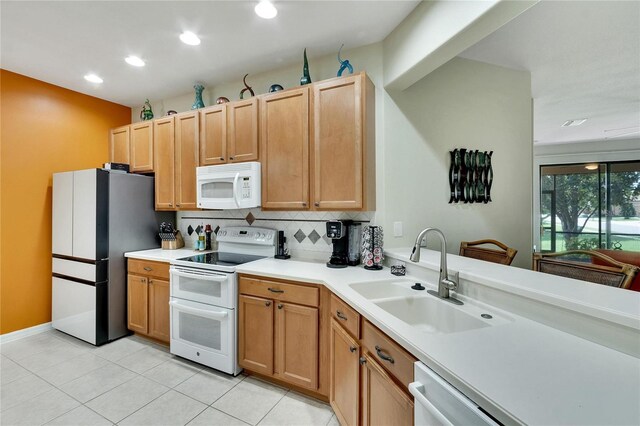 kitchen featuring tasteful backsplash, sink, light tile patterned floors, and white appliances