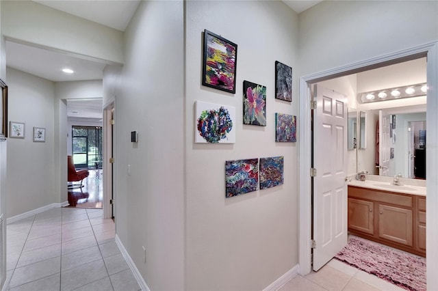 corridor featuring light tile patterned flooring and sink