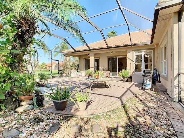 back of property with ceiling fan, a lanai, and a patio