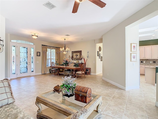 living room with light tile patterned flooring and ceiling fan with notable chandelier