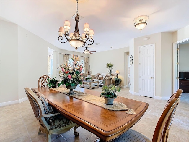 tiled dining space featuring ceiling fan with notable chandelier