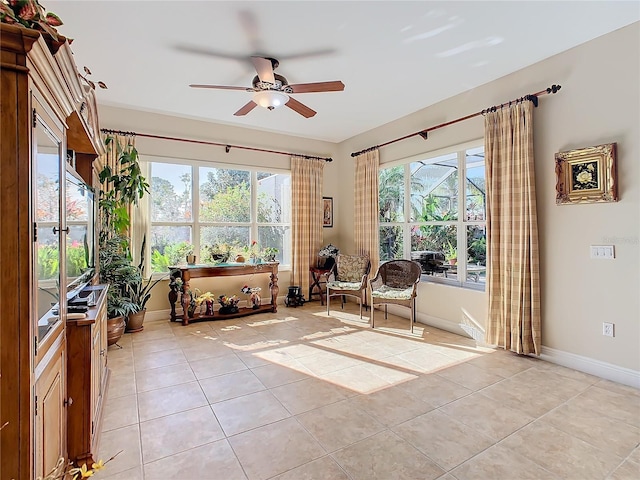 living area with ceiling fan and light tile patterned flooring