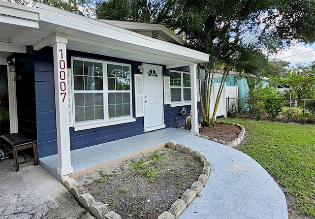 entrance to property featuring a lawn