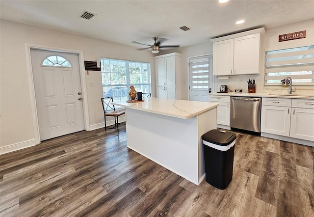 kitchen with stainless steel dishwasher, sink, white cabinets, and a healthy amount of sunlight