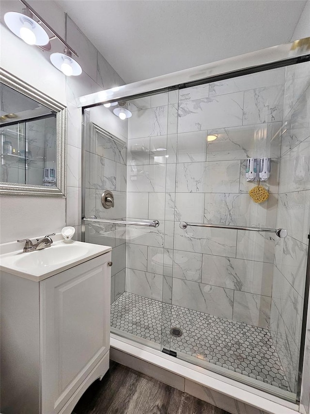 bathroom with vanity, wood-type flooring, and an enclosed shower