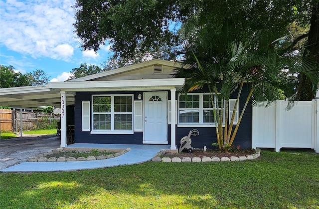 view of front facade with a front lawn and a carport