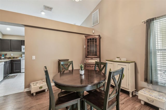 dining room with vaulted ceiling and hardwood / wood-style flooring