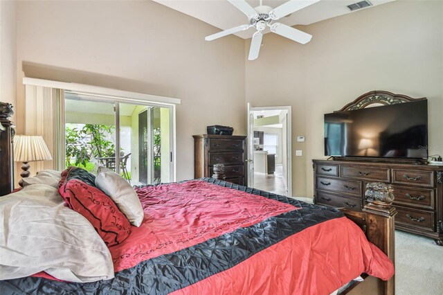 carpeted bedroom featuring a high ceiling, ceiling fan, and access to exterior