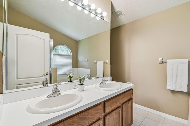 bathroom with vanity, lofted ceiling, and tile patterned flooring