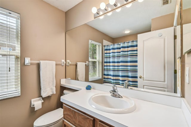 bathroom with a shower with curtain, vanity, and toilet