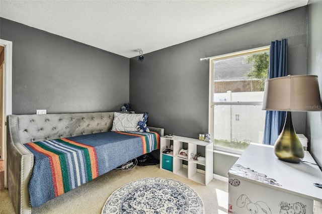 bedroom with light colored carpet and a textured ceiling