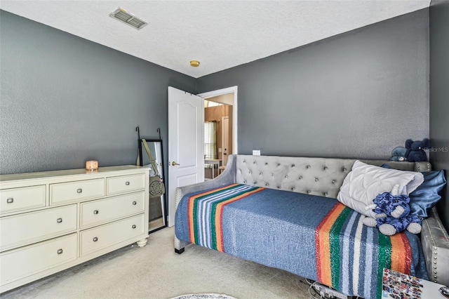 bedroom with a textured ceiling and light colored carpet