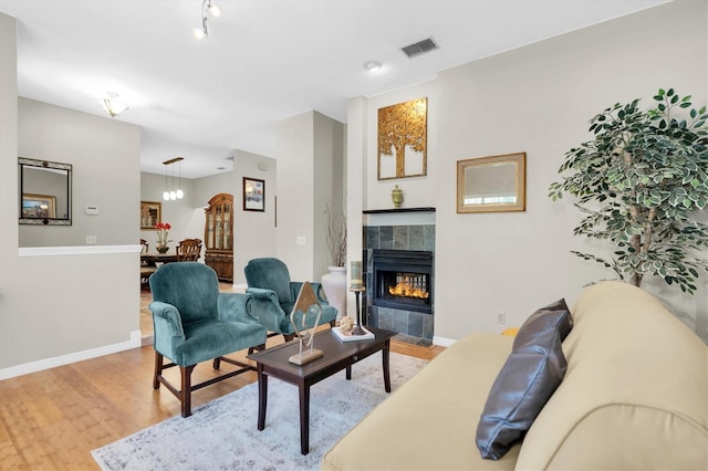 living room with light hardwood / wood-style flooring and a tile fireplace