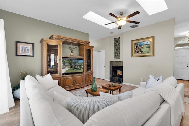 living room featuring ceiling fan and a fireplace