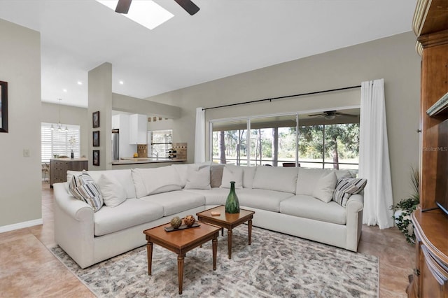 tiled living room with plenty of natural light and ceiling fan with notable chandelier