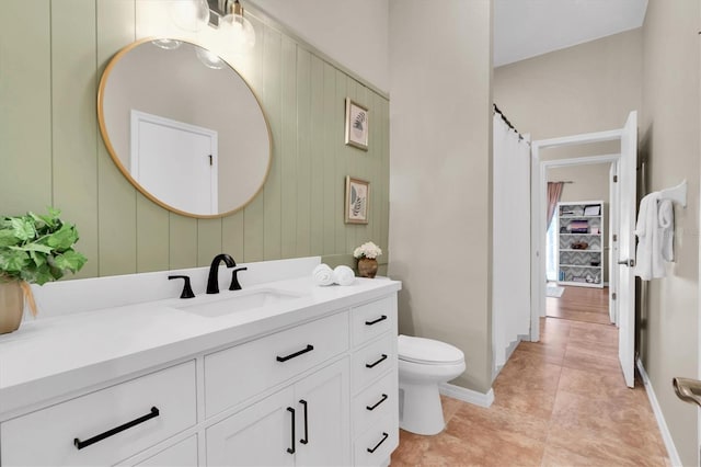 bathroom featuring vanity, toilet, wood walls, and tile patterned flooring