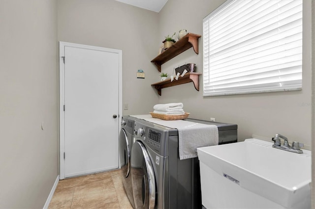 clothes washing area featuring light tile patterned floors, sink, and separate washer and dryer