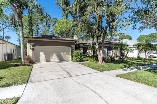 single story home with a front lawn, central AC unit, and a garage