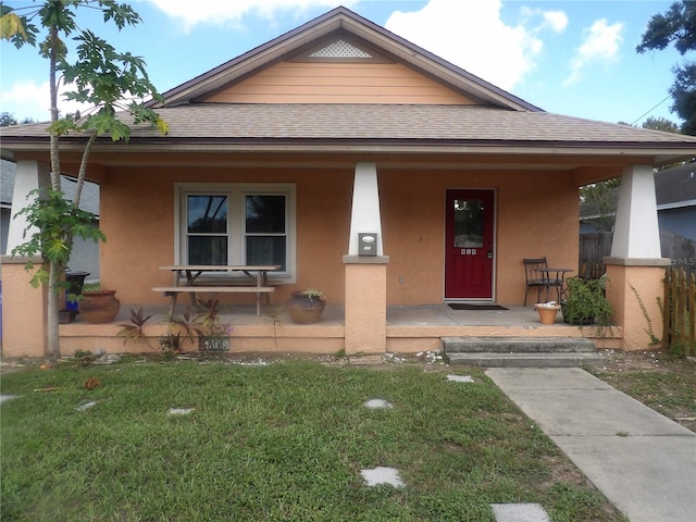 view of front of home with covered porch and a front lawn