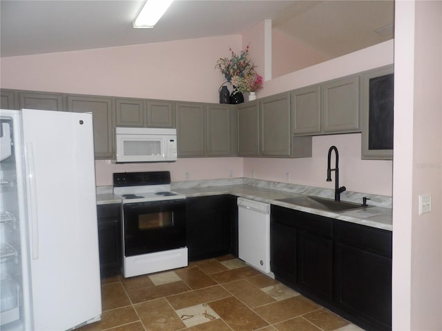 kitchen featuring gray cabinets, sink, vaulted ceiling, and white appliances