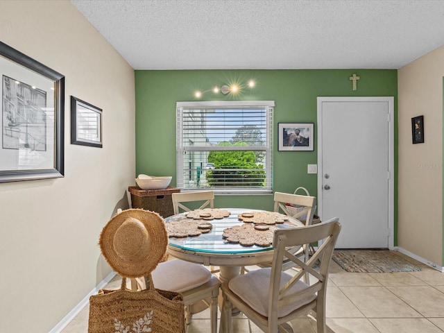 dining area featuring light tile patterned floors and a textured ceiling