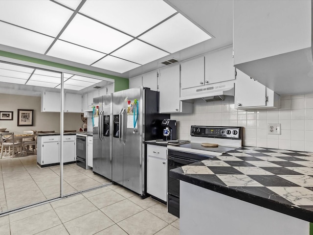 kitchen featuring white cabinets, stainless steel fridge, light tile patterned floors, tasteful backsplash, and white range with electric cooktop