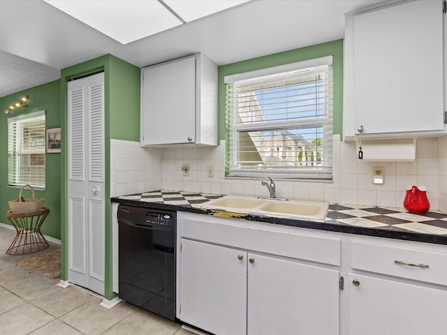 kitchen with decorative backsplash, sink, white cabinetry, light tile patterned floors, and dishwasher