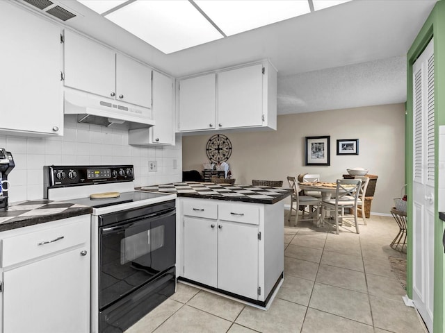 kitchen featuring range with electric cooktop, white cabinets, and light tile patterned floors